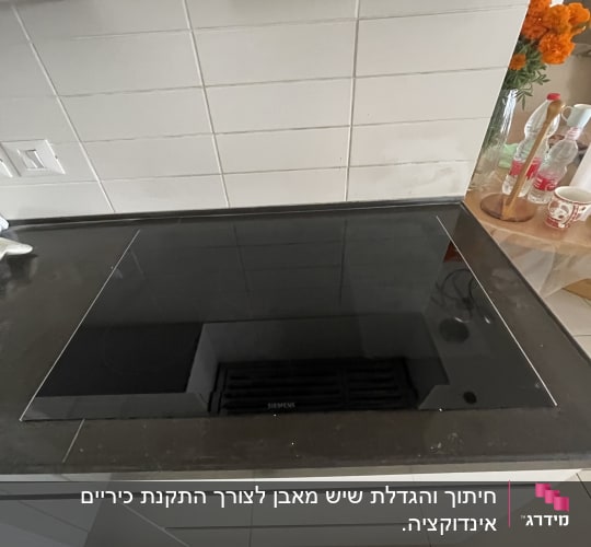 כיריים שחורות על משטח שיש במטבח מודרני
